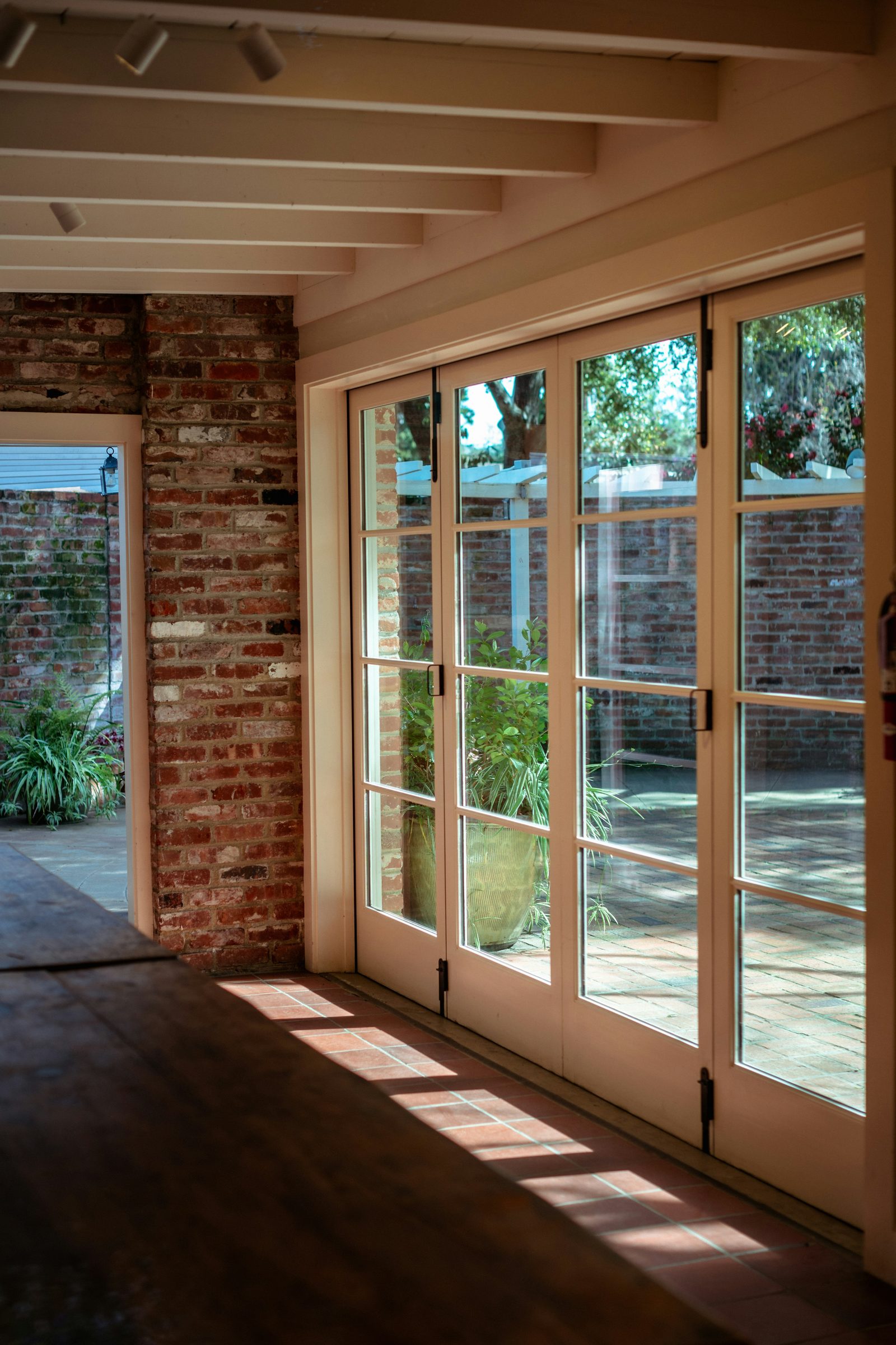 Wood French doors set into an exposed brick reveal